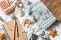 Christmas planning and shopping background. Blue knitted sweater in a paper bag, notepad, phone, christmas decoration on a light b