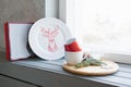 Christmas plate and mugs on the windowsill Royalty Free Stock Photo