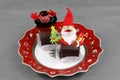 A Christmas plate with sweets and figures of Krampus and Santa Claus or Nicholas