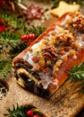 Christmas poppy seed cake,covered with icing and decorated with raisins and walnuts on the holiday table. Royalty Free Stock Photo