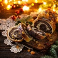 Christmas poppy seed cake, sliced poppy seed cake covered with icing and decorated with raisins and walnuts on the holiday table. Royalty Free Stock Photo