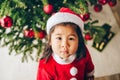 Christmas portrait of adorable 3 year old asian toddler girl wearing red Santa dress and hat Royalty Free Stock Photo