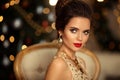 Christmas portrait of elegant woman with wedding hairstyle. Beauty makeup. Beuatiful brunette girl with golden jewelry in prom Royalty Free Stock Photo