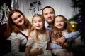 Christmas portrait of family with father, mother and two sisters in home holiday living room decorated for holiday with Royalty Free Stock Photo