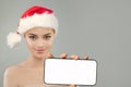 Christmas portrait of healthy cute woman in Santa hat showing smartphone with empty white screen display Royalty Free Stock Photo