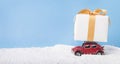 Christmas present on car Volkswagen Beetle among snow on blue
