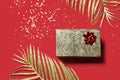 Christmas present in a golden box on red background. Valentines day gift. Royalty Free Stock Photo