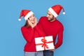 Christmas Present. Handsome Man In Santa Hat Giving Gift Box To Girlfriend Royalty Free Stock Photo