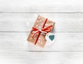 Christmas present with a red ribbon on a white background with snowflakes