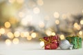christmas present red and silver baubles against bokeh lights gold shiny glitter background with copy space Royalty Free Stock Photo