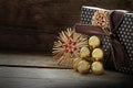 Christmas present in with straw stars and golden baubles on a da Royalty Free Stock Photo