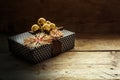 Christmas present with straw stars and golden baubles on dark ru Royalty Free Stock Photo