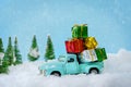 Christmas presents on blue truck riding through a snowy forest Royalty Free Stock Photo
