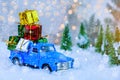 Christmas presents on blue truck riding through a snowy forest Royalty Free Stock Photo