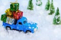 Christmas presents on blue truck riding through a snowy forest Royalty Free Stock Photo