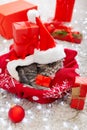 Christmas presents. Christmas cat kitten wearing Santa Claus hat holding gift box sleeping on plaid under christmas tree. Royalty Free Stock Photo