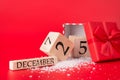 Christmas and presents concept. Close up photo of wooden cube calendar showing date of christmas and an open red giftbox with red Royalty Free Stock Photo