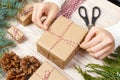 Christmas presents preparation. Gift box wrapped in black and white striped paper, a crate full of pine cones and Royalty Free Stock Photo