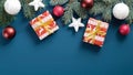 Christmas presents wrapped festive paper, white and red balls, stars, pine tree branches over blue background. Flat lay, top view Royalty Free Stock Photo