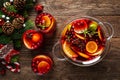 Christmas punch. Festive red cocktail, drink with cranberries and citrus fruits in a punch bowl and glasses