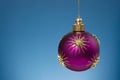 Christmas purple ball with gold stars on festive blue background. Christmas ornaments and New Year decor Royalty Free Stock Photo