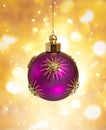Christmas purple ball with gold stars on festive bokeh background. Christmas ornaments and New Year decor Royalty Free Stock Photo