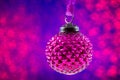 Christmas purple bauble on purple glitter blurred background with copy space