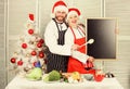 Christmas recipe concept. Menu for our family. Man and woman chef santa hat near christmas tree hold blackboard copy