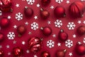 Christmas red background with red baubles, glitter and snowflakes with copy space. Winter christmas frame border Royalty Free Stock Photo