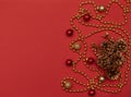 Christmas red background with fir cones, golden beads and Christmas decoration Royalty Free Stock Photo