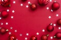 Christmas red background with red baubles and glitter with copy space. Winter christmas frame border Royalty Free Stock Photo