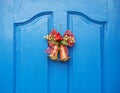 Christmas red bow  hanging on old wooden blue door Royalty Free Stock Photo