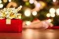 Christmas Red Gift Box with Golden Bow in Bokeh Lights Background Royalty Free Stock Photo