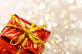 Christmas red gift box with yellow bow on glitter silver and gold background Royalty Free Stock Photo