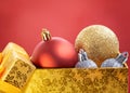 Christmas red, gold, silver balls in open yellow box on red background. New Year decor Royalty Free Stock Photo