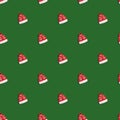 Christmas red hat with deers on green background, seamless pattern. Santa Claus hat Royalty Free Stock Photo