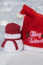 Christmas red hat and a lovely snowmen toy on the white snow,
