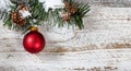 Christmas red ornament hanging from snowy rough fir tree branch Royalty Free Stock Photo