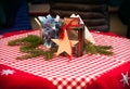 Christmas, red tablecloth with stars. wooden star, sugar, and container for candle