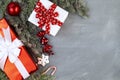 Christmas red and white gifts with ribbon and decoration with snowy pine branches and foliage over stone like background. Top view Royalty Free Stock Photo