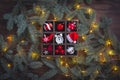 Christmas red and white glass toys, alarm clock, santa claus hat in the basket with fir tree branches background