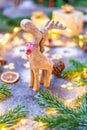 Christmas reindeer wooden toy statue with pine tree, cone and winter light in background Royalty Free Stock Photo