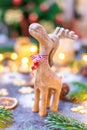 Christmas reindeer wooden toy statue with pine tree, cone and winter light in background Royalty Free Stock Photo