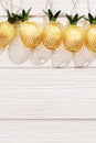 Christmas rustic background with string lights as pineapples golden colored. Festive decoration, New Year fairy garland. Royalty Free Stock Photo