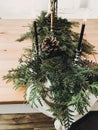 Christmas rustic decor of table. Vintage candlestick with burning candles,pine branches with cones on wooden table, festive Royalty Free Stock Photo