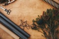 Christmas rustic flat lay. Stylish wrapping paper, wooden star, pine branches and cones, thread on rural wooden table, copy space