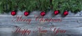 Christmas rustic natural wooden background with fir branches and red ball ornaments plus text Royalty Free Stock Photo