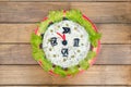 The Christmas salad rice olives greens peas - concept New year clock face, midnight, brown wooden background. Royalty Free Stock Photo