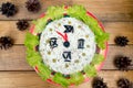 The Christmas salad rice olives greens peas - concept New year clock face, midnight, brown wooden background spruce