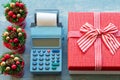 Christmas sale. Cash register, red gift box with ribbon and small Christmas trees with cone Buying gifts for Christmas